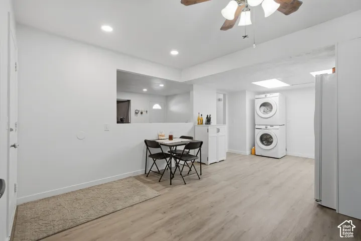 Recessed ceiling lighting, wood-finish flooring, white walls, built-in cabinetry, and a ceiling fan