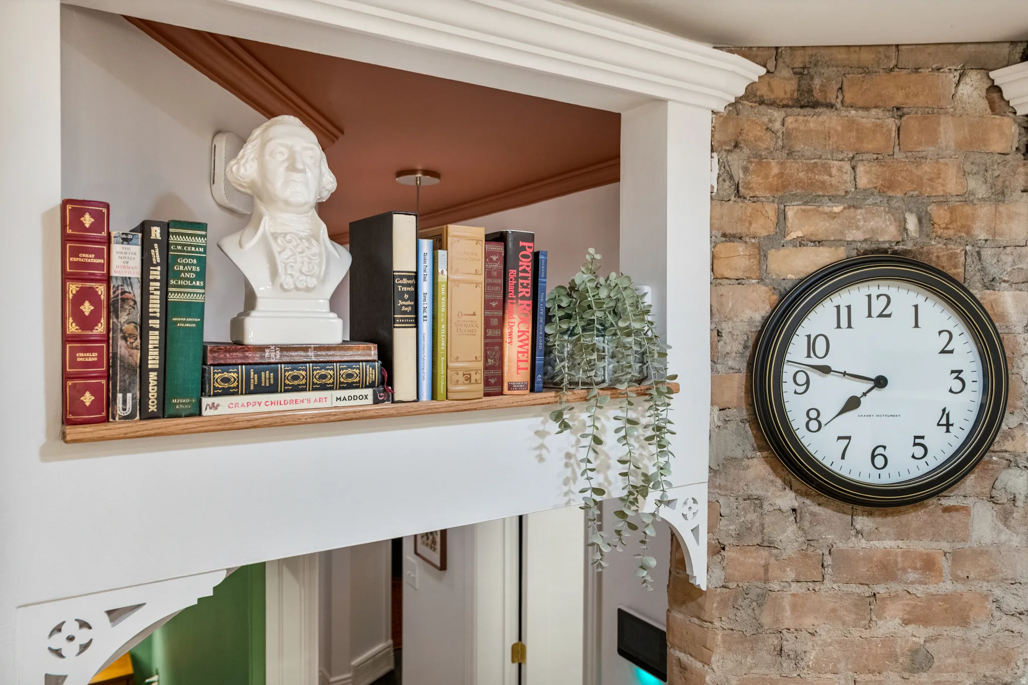 Exposed brick wall detail with an integrated built-in shelf featuring decorative corbels and crown molding