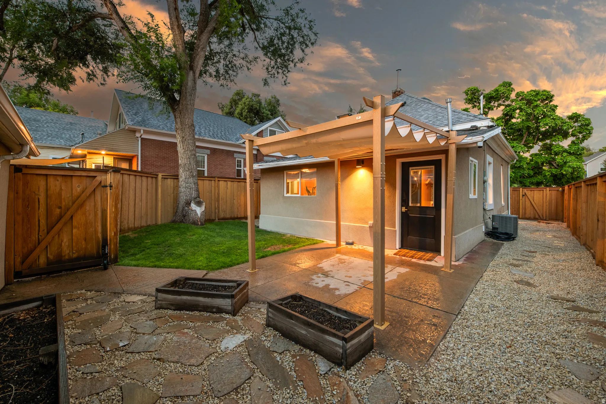 Stone paver patio with gravel accents, leading to a covered outdoor seating area