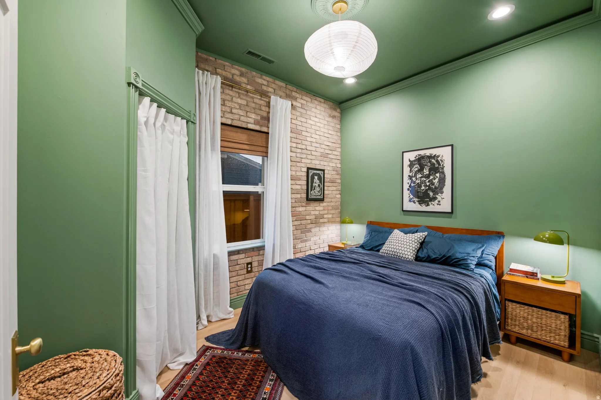 Exposed brick accent wall, light wood-finish flooring, recessed lighting, crown molding, and a decorative ceiling medallion