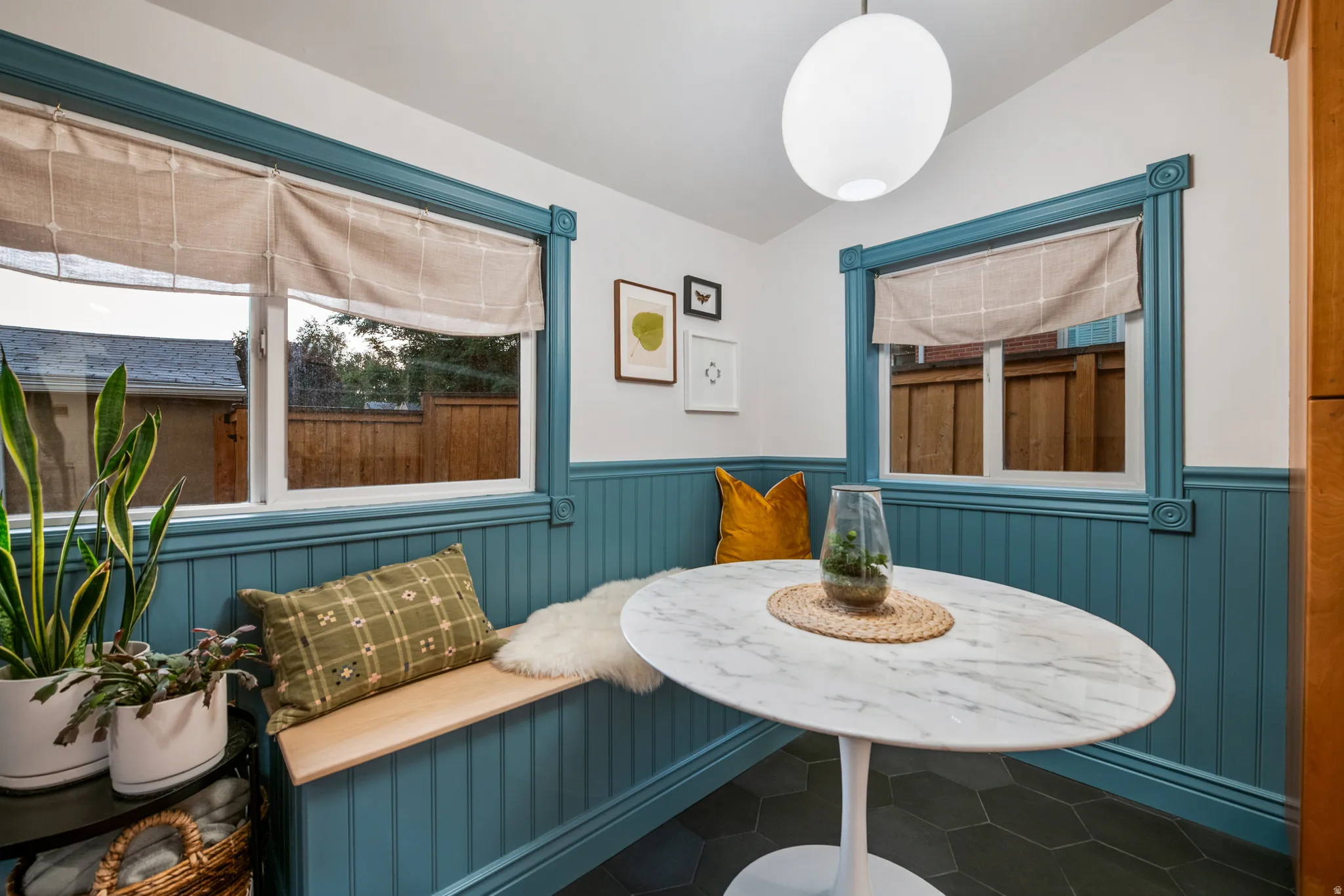 Built-in corner bench seating, accent wainscoting, and decorative window trim