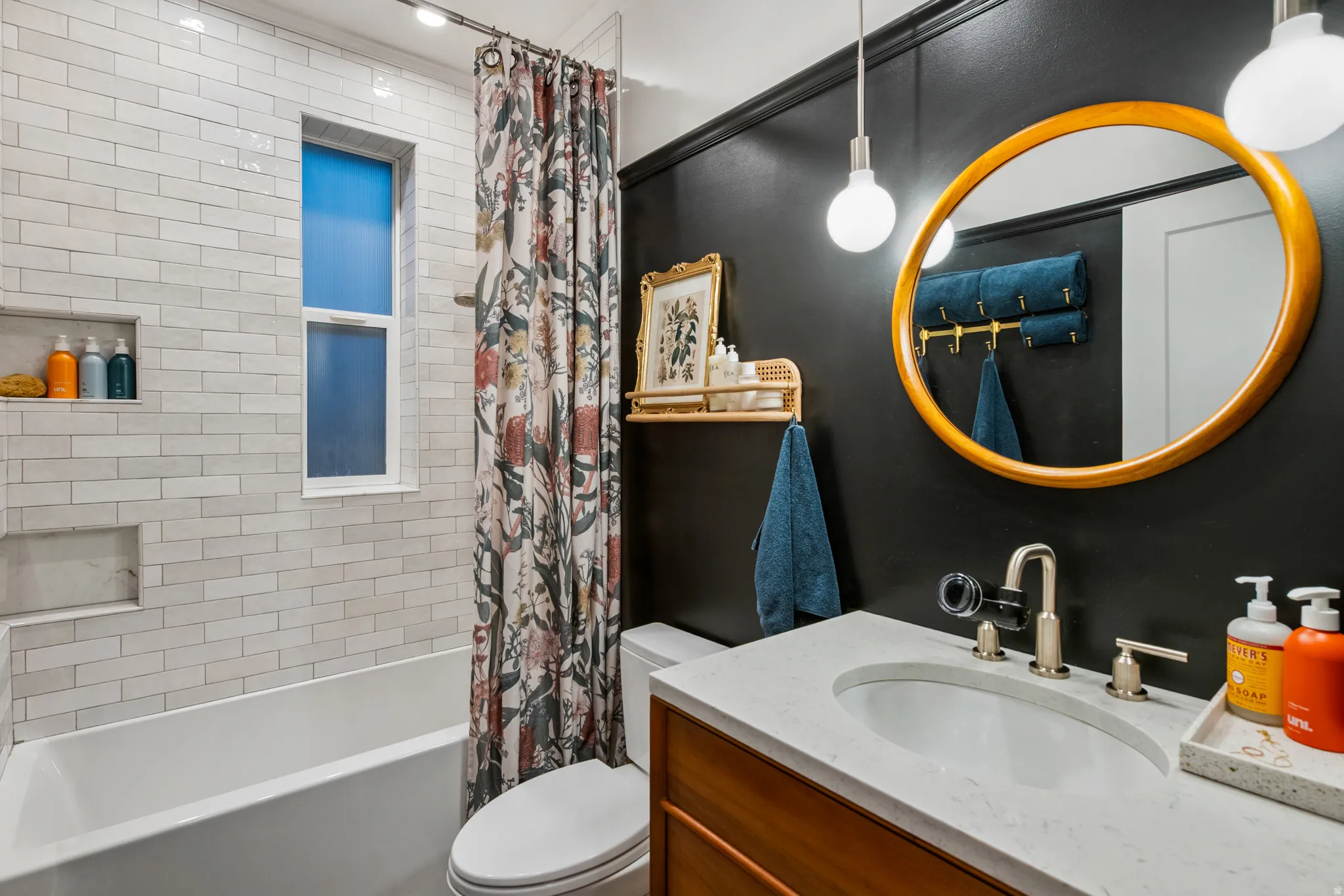Built-in bathtub with subway tile surround and recessed shelving