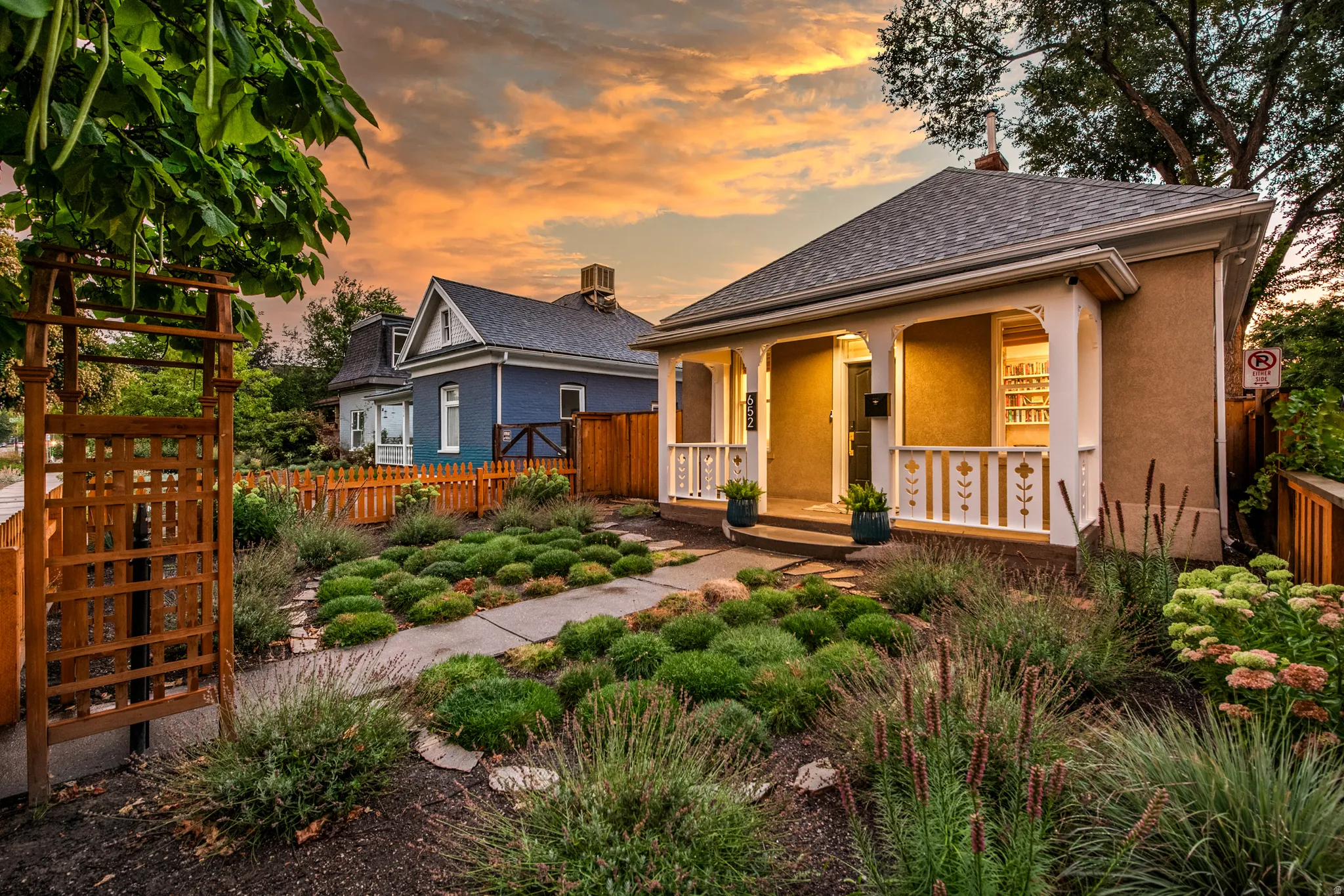 Front exterior with a covered porch, decorative porch railings, and a stucco finish