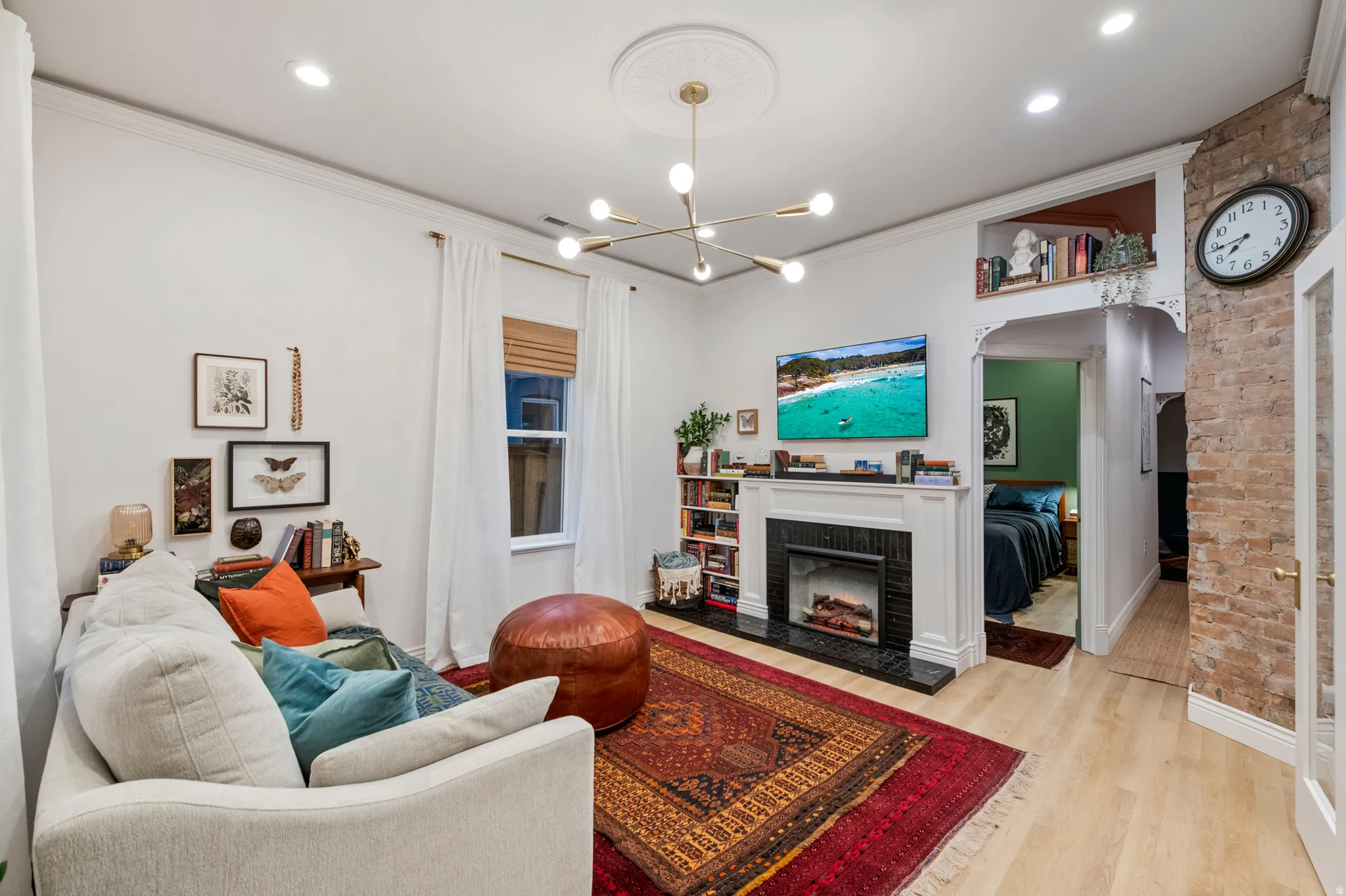 Hardwood-style flooring throughout, featuring a decorative fireplace with a black surround and white mantel