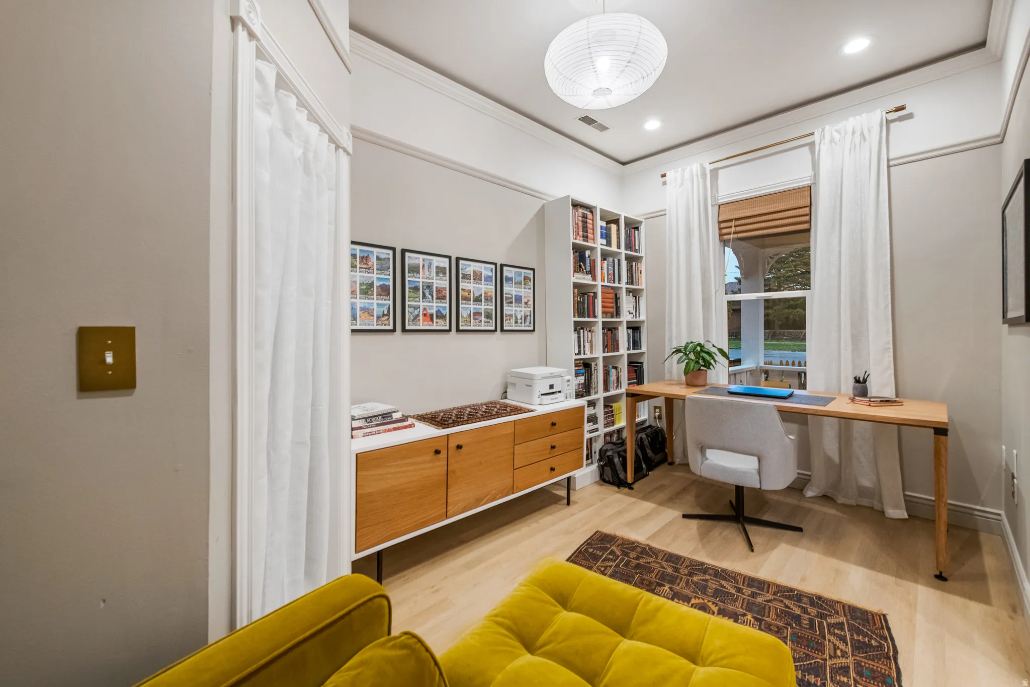 Recessed lighting, wood-finish flooring, built-in shelving, window with wood blinds, and a drum pendant light fixture