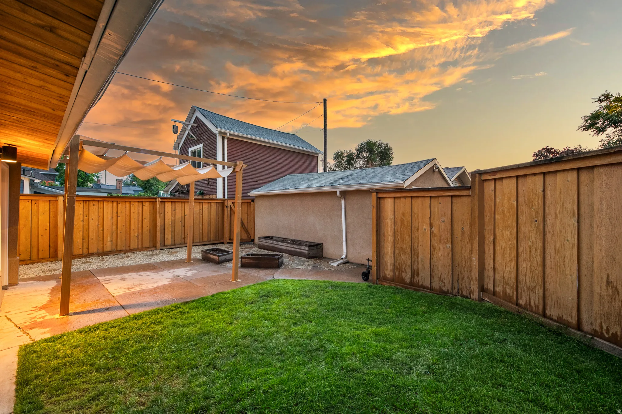 Manicured lawn with a privacy fence, concrete patio, pergola, and wood finish ceiling