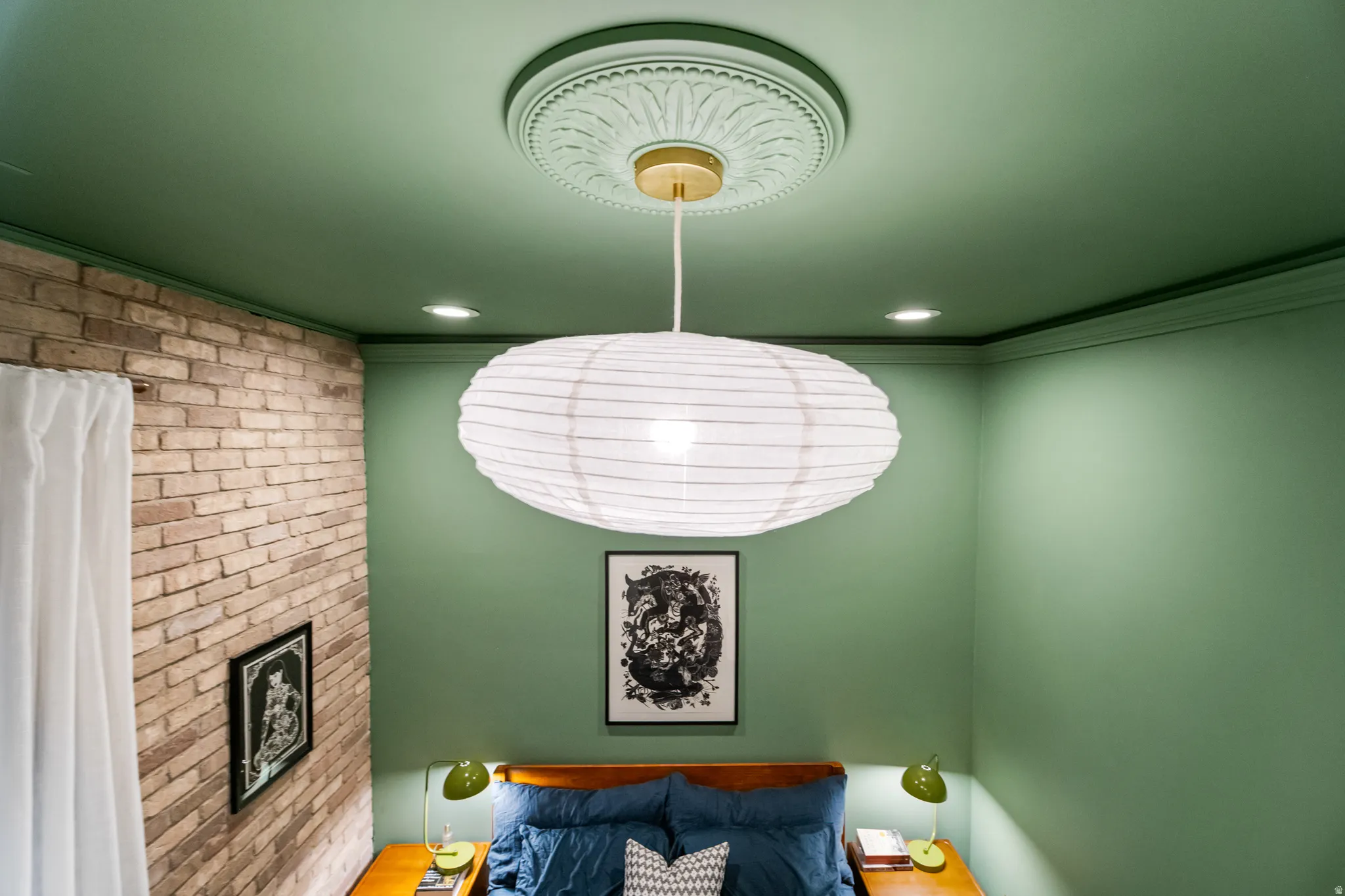 Exposed brick wall with a painted ceiling and recessed lighting