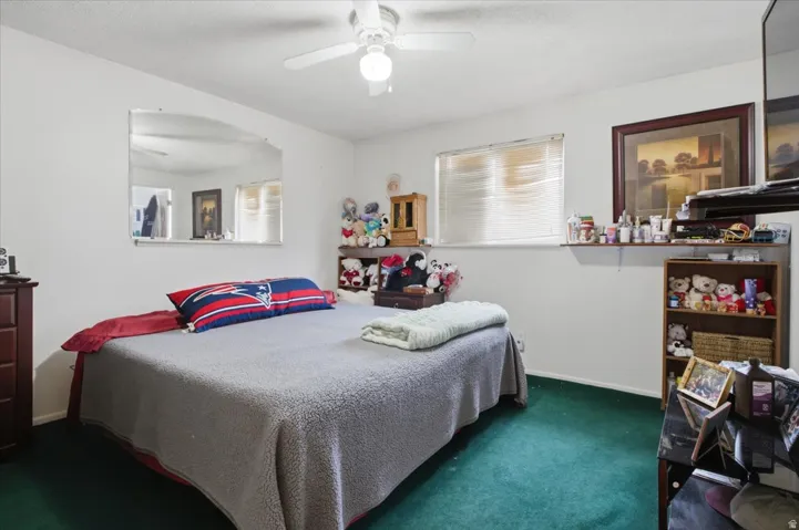 Bedroom with ceiling-mounted light fixture, and carpeted flooring.