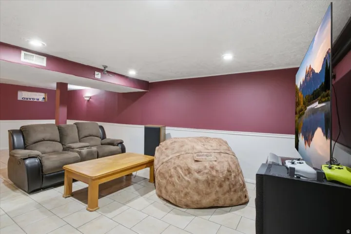 Recessed lighting illuminates the space, featuring tile flooring and a two-tone wall finish