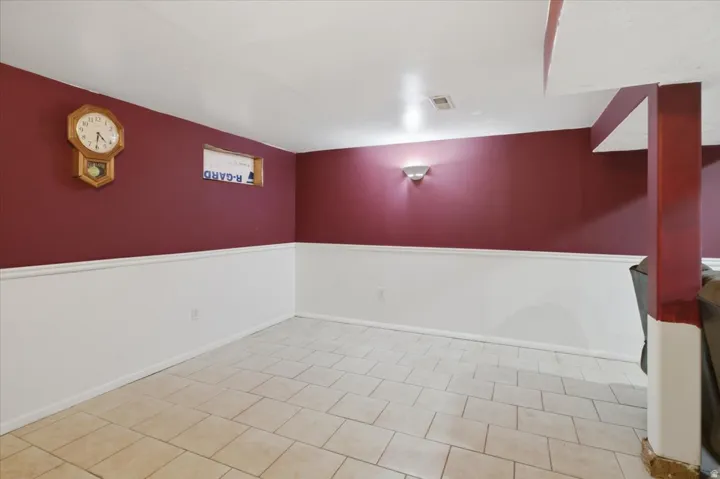 Tiled flooring, two-tone wall treatment, wall-mounted sconce, and recessed lighting