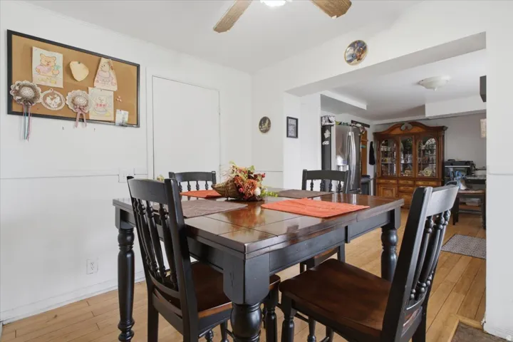 Light wood-finish flooring with white baseboards and painted walls