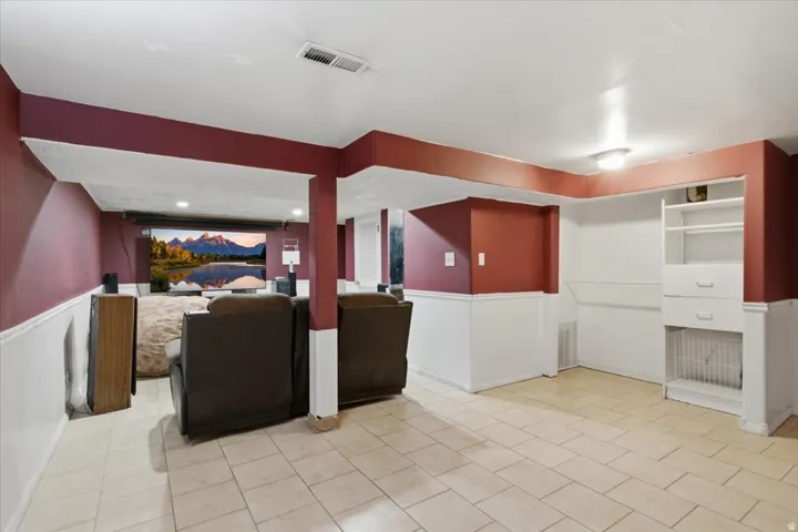 Recessed lighting, tile flooring, built-in shelving, and a large projection screen
