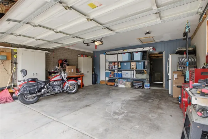 Spacious garage with concrete flooring and exposed ceiling joists