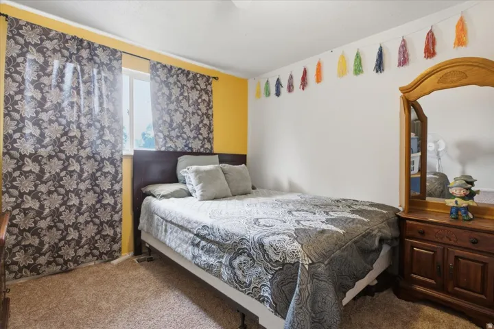 Wall-to-wall carpeting and a single window with a dark frame