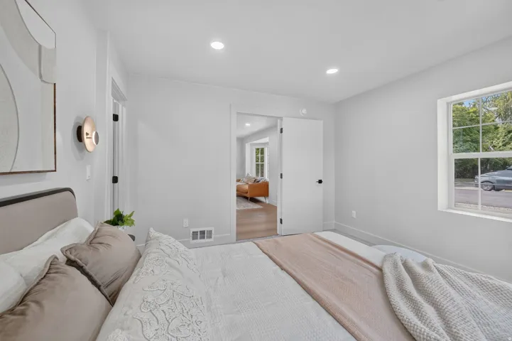 Recessed ceiling lighting, white interior doors with matte black hardware, white trim, and a window with natural light