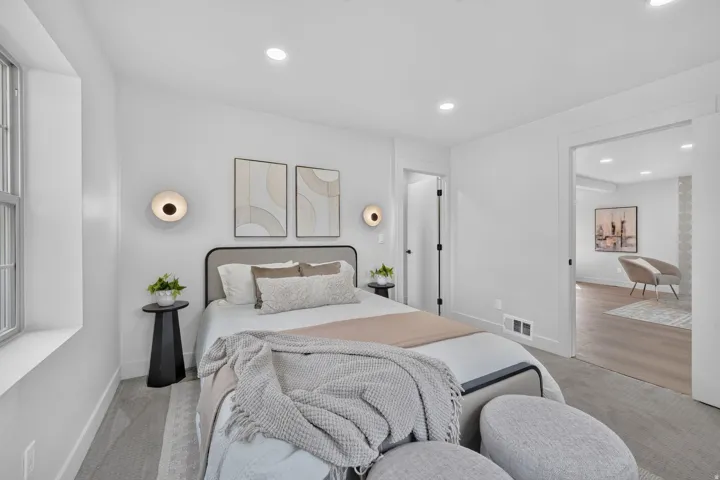 Recessed lighting, window with grids, sconce lighting, white walls, wood-finish flooring