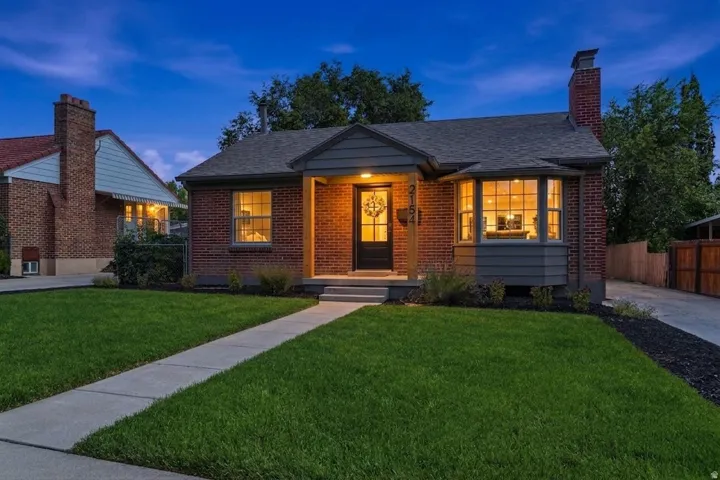 Brick exterior with contrasting dark gray siding, prominent bay window, and a gray shingled roof