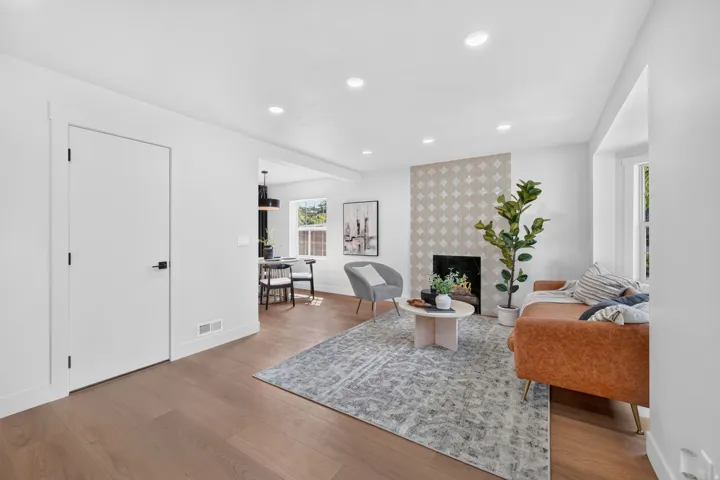 Hardwood-style flooring, recessed lighting, and a patterned tile fireplace
