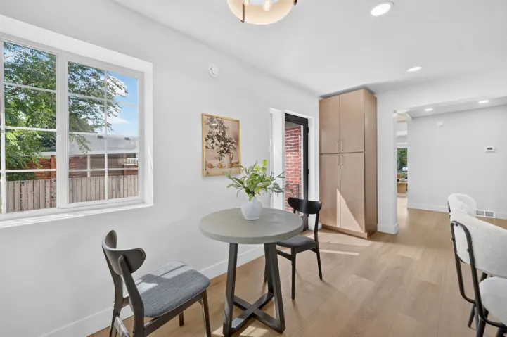 Crisp white walls, wood-finish flooring, recessed lighting, and a built-in storage cabinet