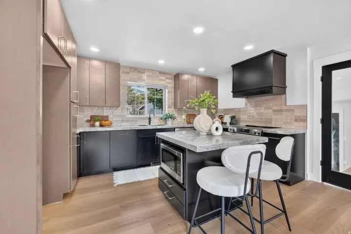 Kitchen featuring wood-finish flooring, recessed lighting, and a two-tone cabinetry design