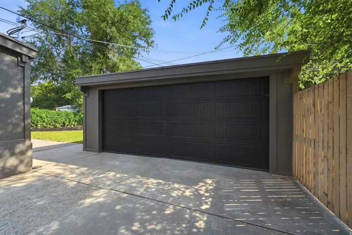 Attached garage with a panel-style door and concrete driveway