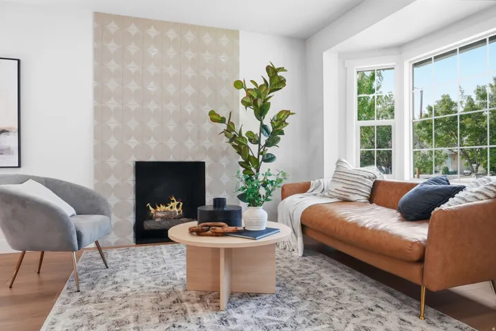 Decorative fireplace surround, wood-finish flooring, and bay windows