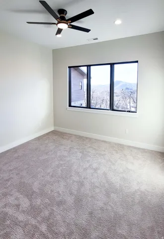 Neutral tone wall finishes with recessed lighting and a ceiling fan