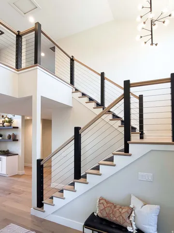 Open-tread staircase with wood-finish steps and cable railing