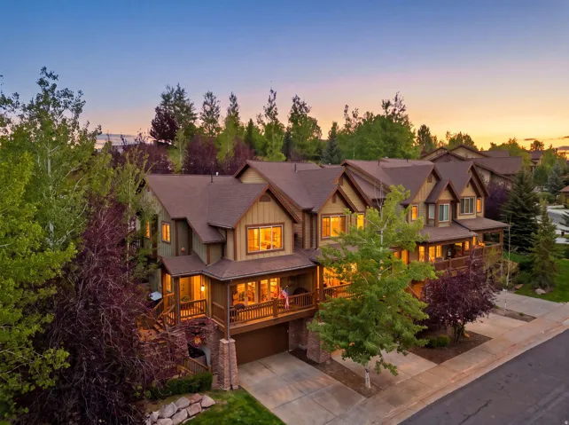 Multi-level property with an attached garage, covered balconies, and stone accents