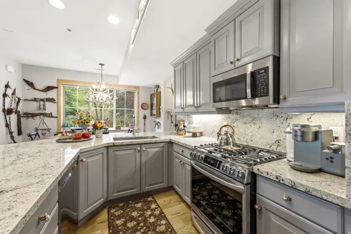 Gray cabinetry with granite countertops, stainless steel appliances, under mount sink, and recessed lighting