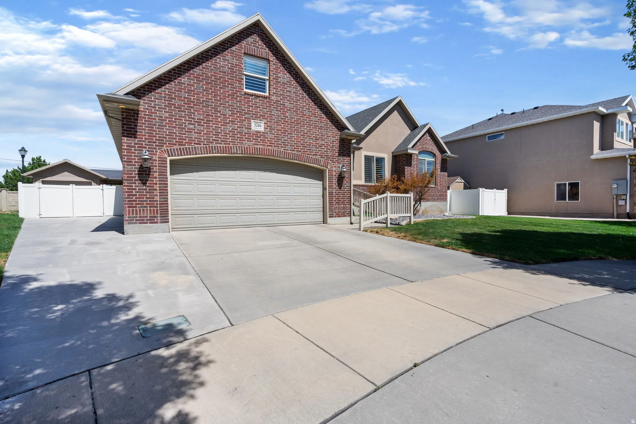Brick exterior with an arched garage door and a concrete driveway