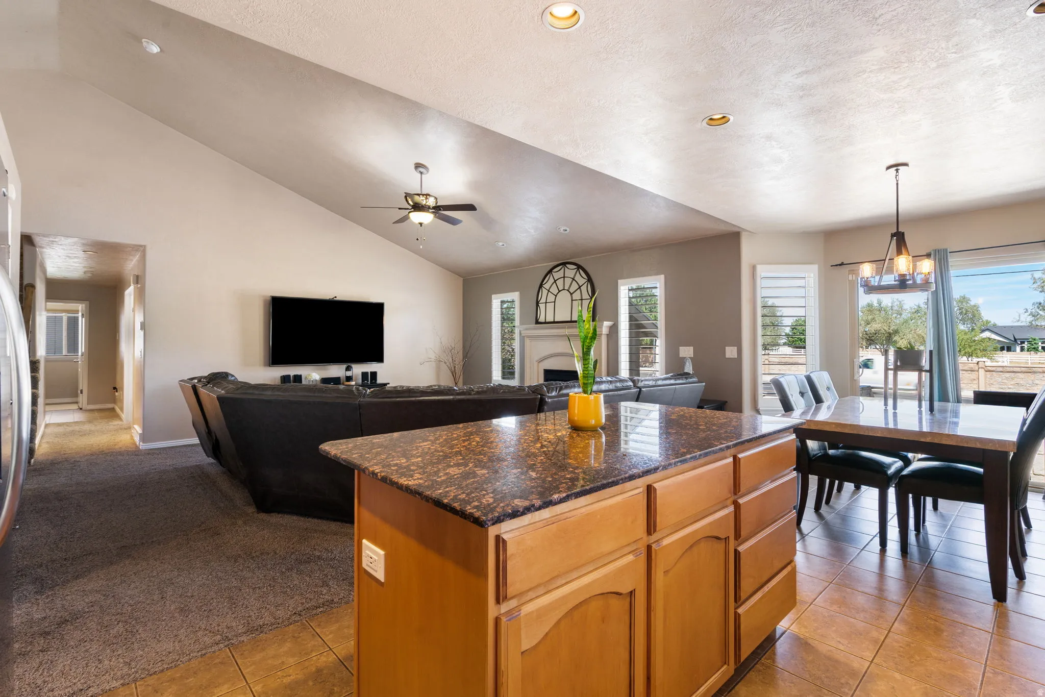 Open-concept living area featuring a vaulted ceiling with a ceiling fan, recessed lighting, and tile flooring