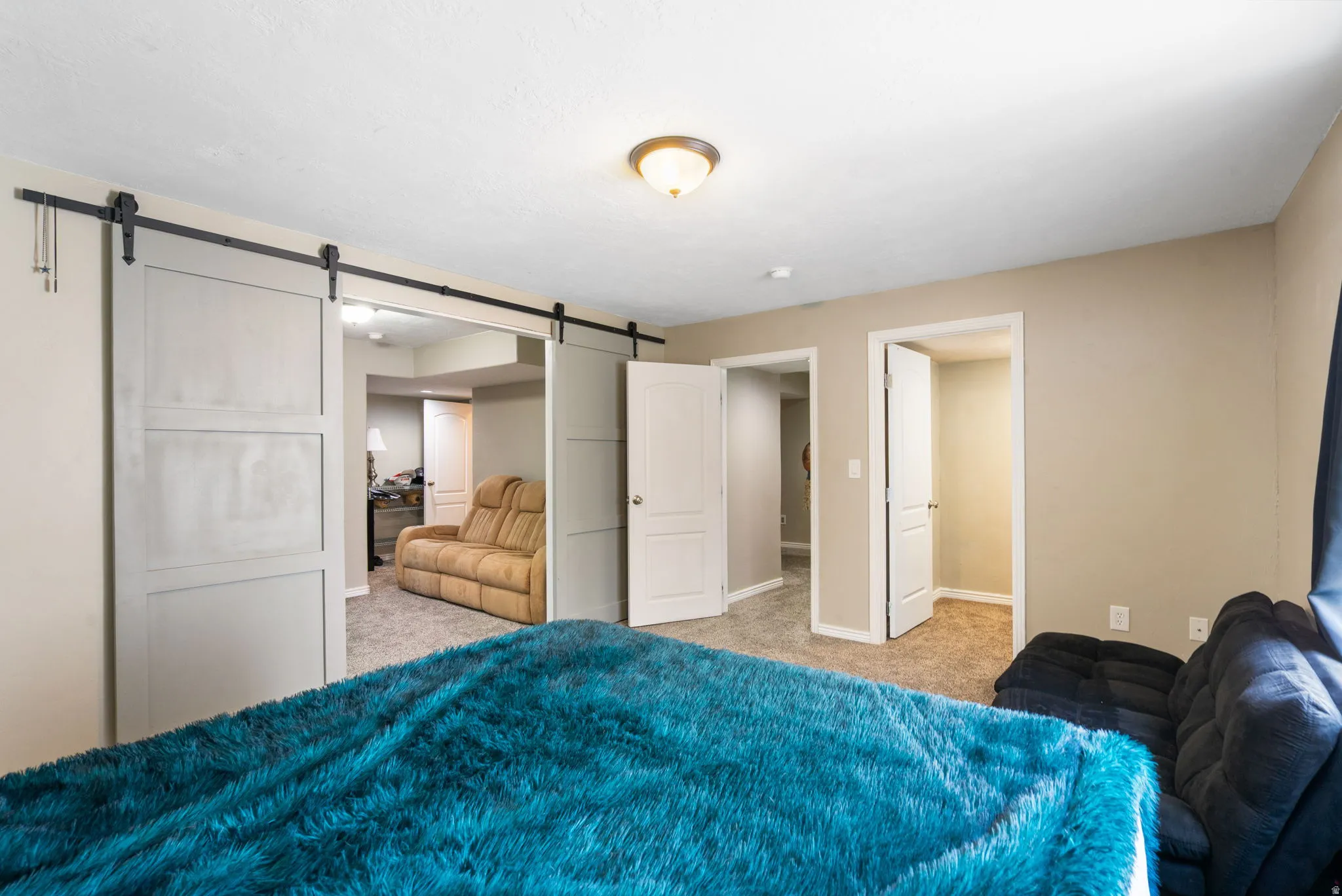 Barn door entry to an additional room, recessed lighting, and carpeted flooring