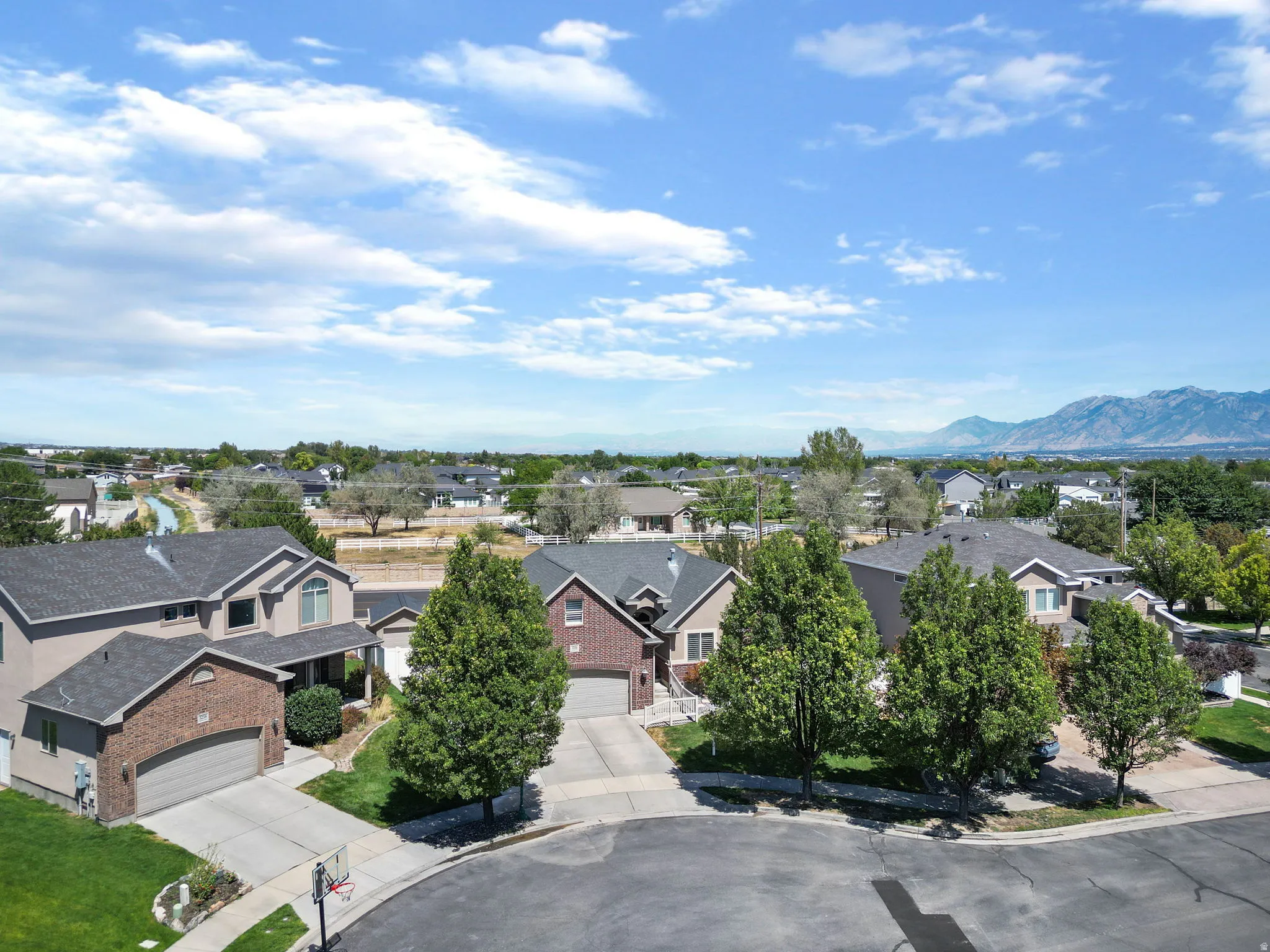 Residential property with mountain backdrop, surrounded by trees and residential structures
