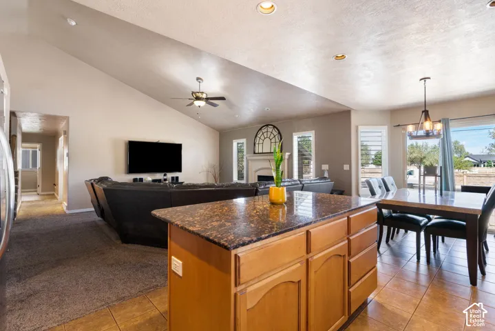 Open-concept living area featuring a vaulted ceiling with a ceiling fan, recessed lighting, and tile flooring