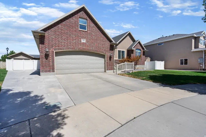 Brick exterior with an arched garage door and a concrete driveway