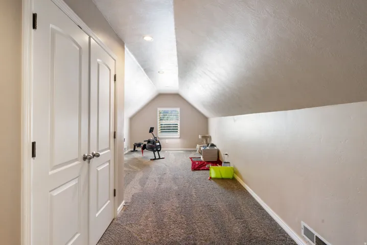 Carpeted area with a window, recessed lighting, and white bi-fold doors