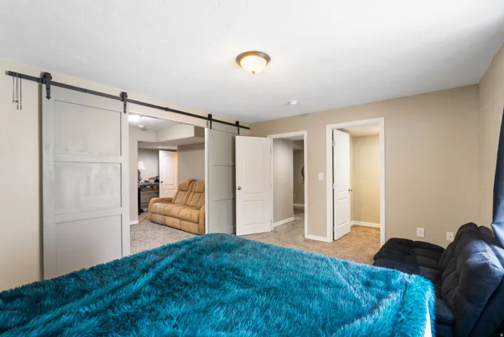 Barn door entry to an additional room, recessed lighting, and carpeted flooring