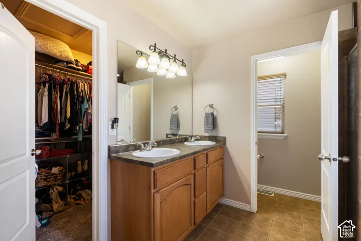 Dual vanity with integrated sinks, wood-finish cabinetry, and a large wall-mounted mirror
