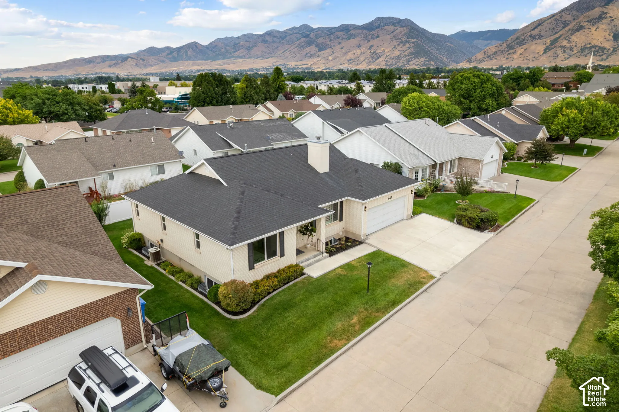 Single-story residence with an attached garage, concrete driveway, and manicured landscaping