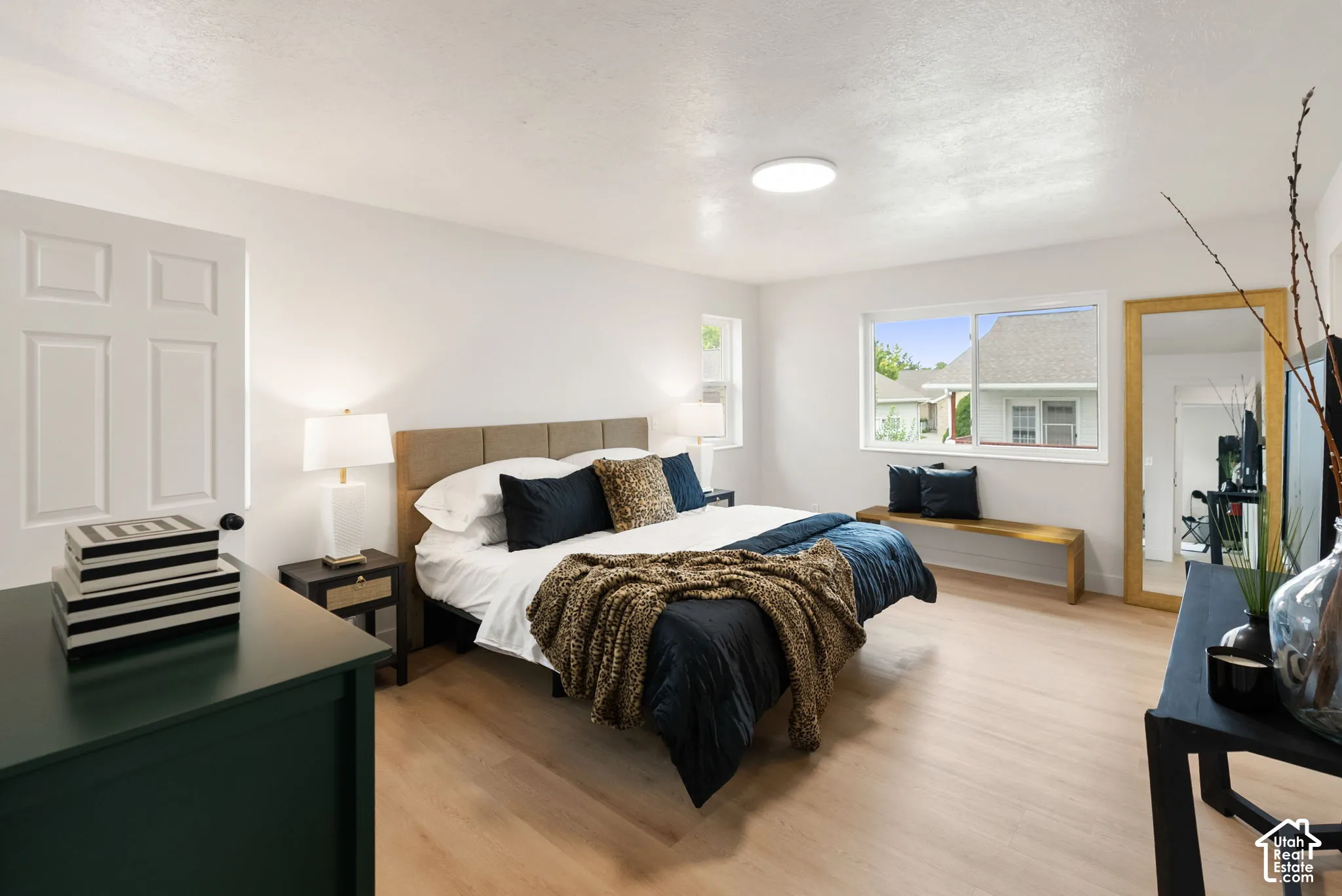 Light wood-finish flooring, white walls, and a large window providing natural illumination