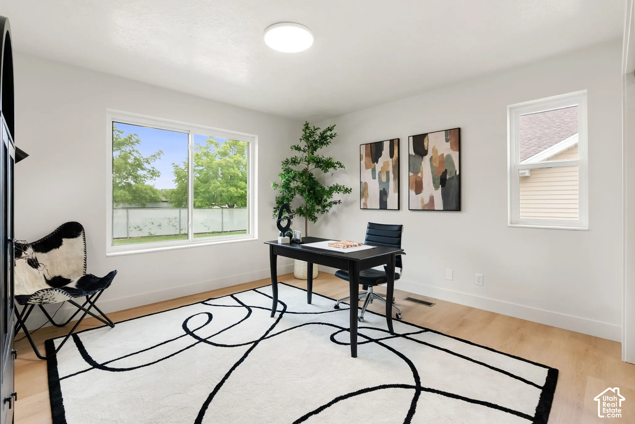 Light wood-finish flooring, white walls, and a flush-mount ceiling light