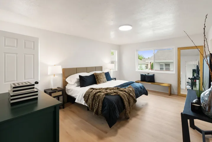 Light wood-finish flooring, white walls, and a large window providing natural illumination