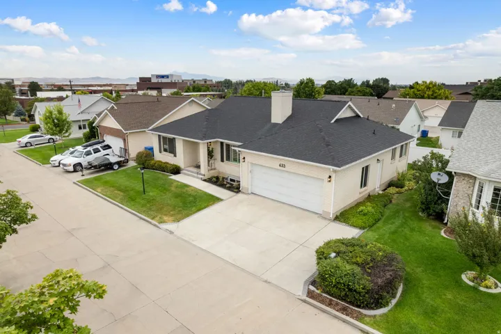 Ranch-style residence featuring an attached two-car garage, concrete driveway, and a dark shingle roof