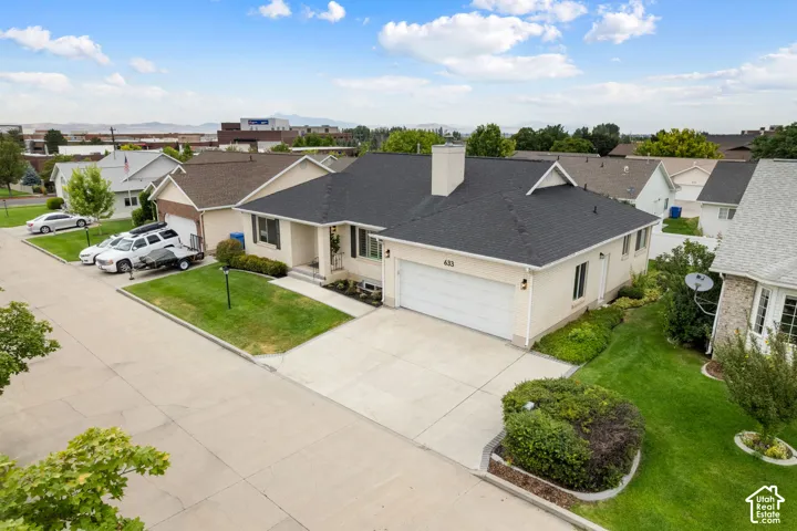Ranch-style residence featuring an attached two-car garage, concrete driveway, and a dark shingle roof