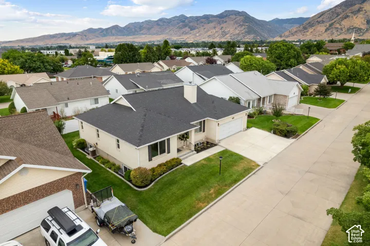Single-story residence with an attached garage, concrete driveway, and manicured landscaping