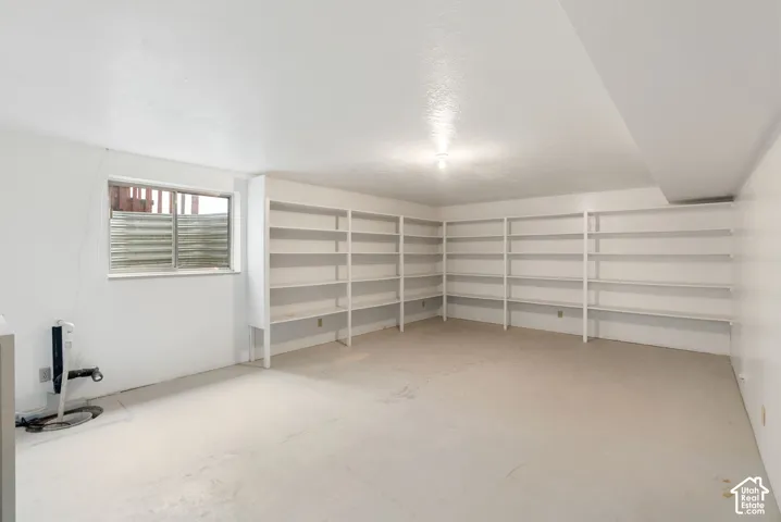 Extensive built-in shelving, painted concrete flooring, and a single-pane window