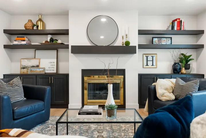 Integrated fireplace with brass-finish trim, a substantial mantel, and flanking built-in cabinetry