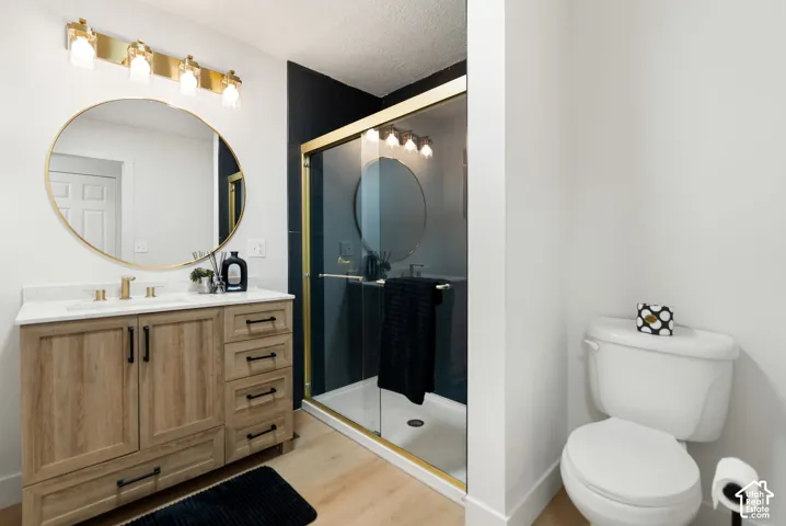Vanity with wood-finish cabinetry, white countertop, and gold-finish hardware