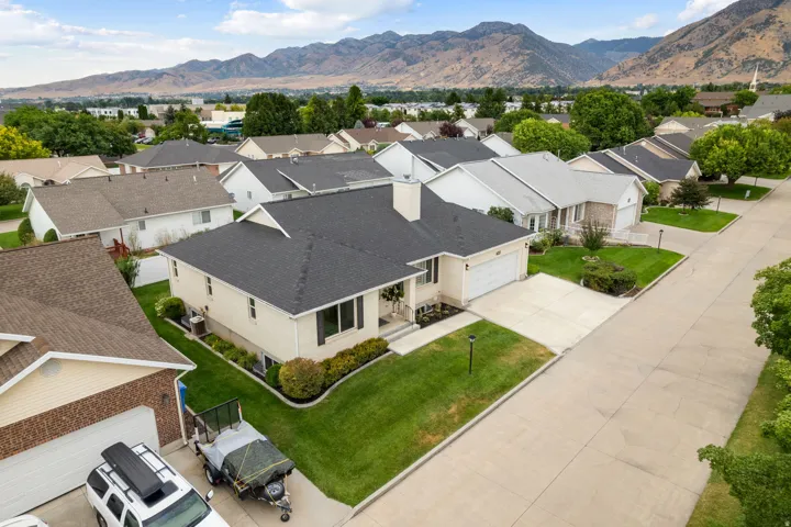 Single-story residence with an attached garage, concrete driveway, and manicured landscaping